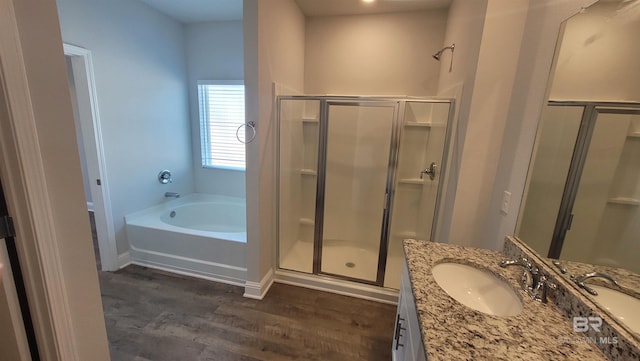 bathroom with hardwood / wood-style flooring, vanity, and plus walk in shower