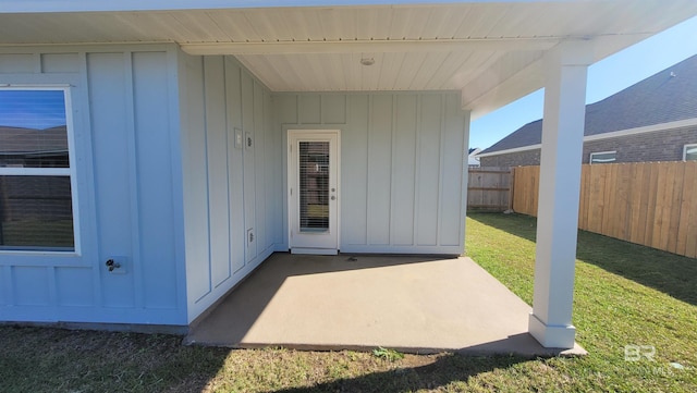 entrance to property with a patio area and a lawn