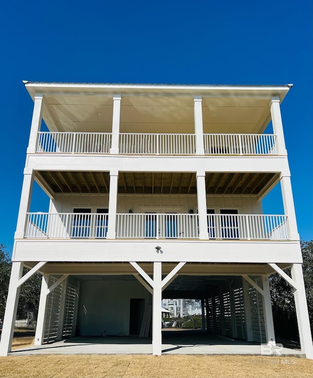 rear view of property with a carport, board and batten siding, and driveway