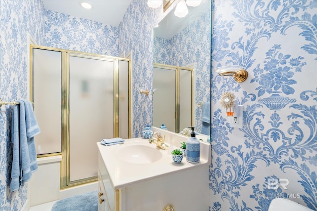 bathroom featuring a shower with shower door and oversized vanity