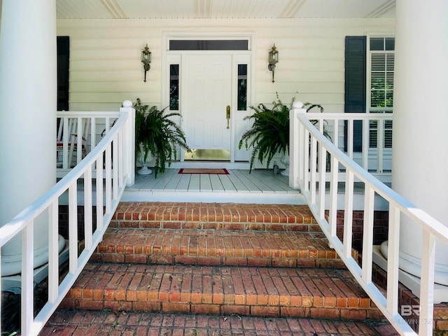 view of exterior entry featuring covered porch