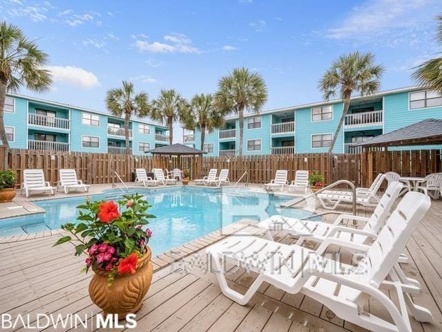 728 W Beach Blvd Unit 121, Gulf Shores, AL 36542 - community pool with a fenced backyard and a deck