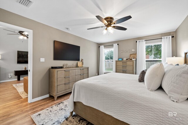 bedroom featuring baseboards, multiple windows, light wood-type flooring, and visible vents
