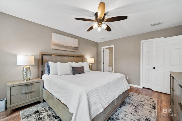 bedroom featuring baseboards, a ceiling fan, wood finished floors, and visible vents