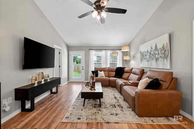 living area featuring baseboards, ceiling fan, vaulted ceiling, and wood finished floors