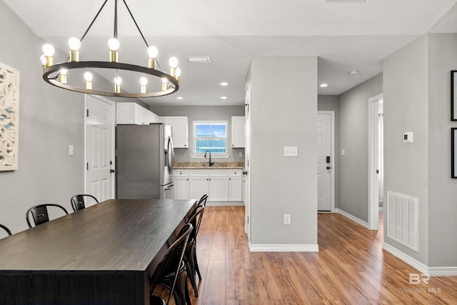 dining area with a chandelier, recessed lighting, baseboards, light wood-type flooring, and visible vents