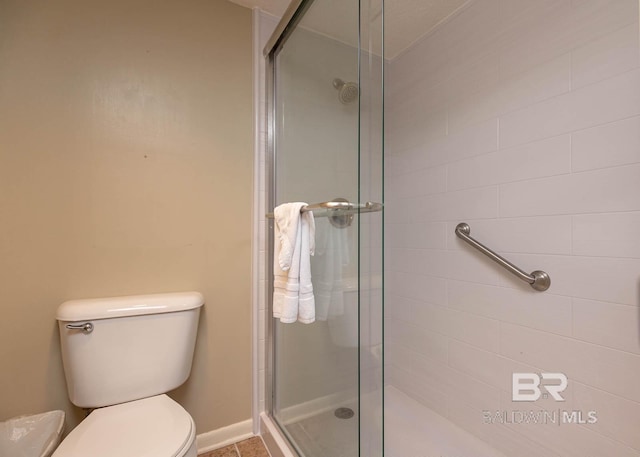 bathroom with a shower with shower door and toilet