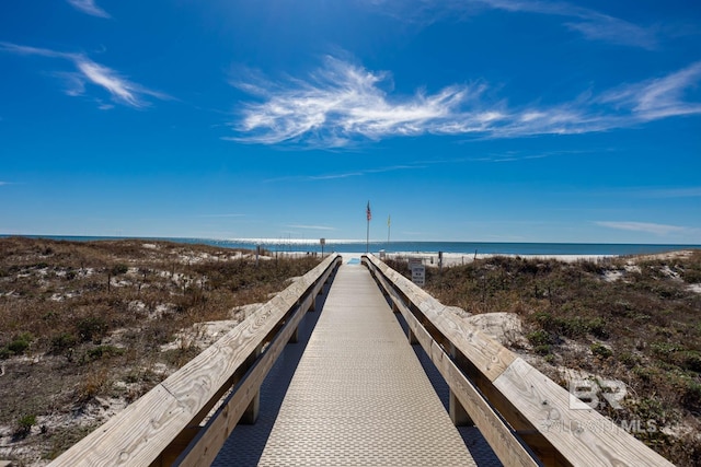 surrounding community featuring a water view and a beach view