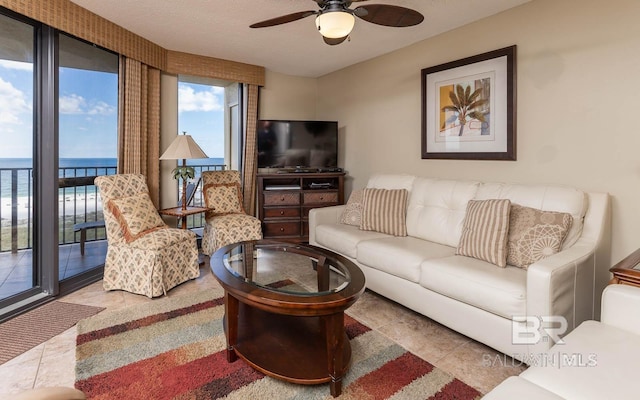 tiled living room featuring a textured ceiling and ceiling fan