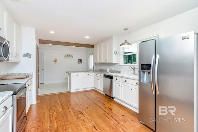 kitchen with white cabinetry, hanging light fixtures, light hardwood / wood-style floors, and appliances with stainless steel finishes