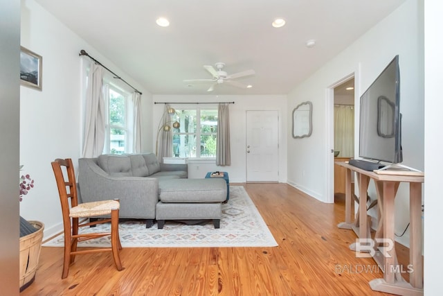 living room with light hardwood / wood-style floors and ceiling fan