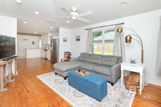 living room with ceiling fan and light hardwood / wood-style floors