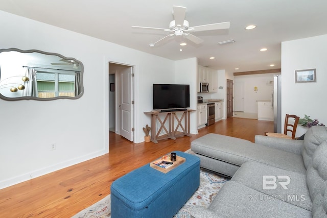 living room with hardwood / wood-style floors and ceiling fan