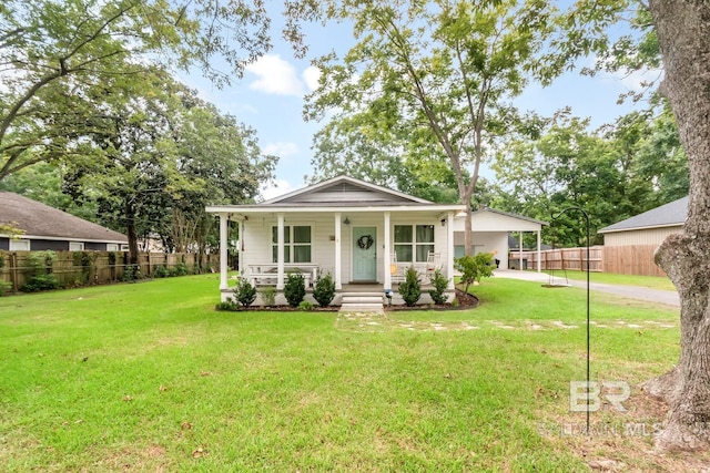 view of front of home with a front lawn, a carport, and covered porch