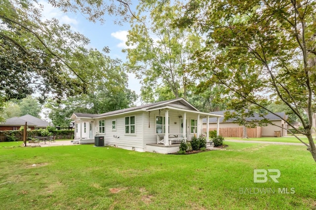 rear view of property with a porch, central air condition unit, and a lawn