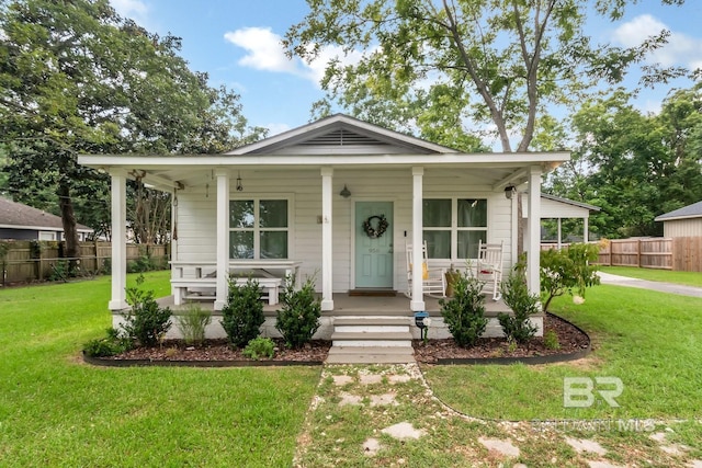 view of front of home with covered porch and a front lawn