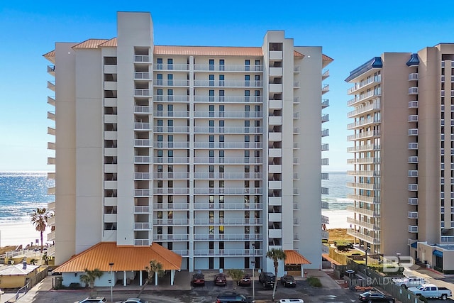 view of building exterior with a beach view and a water view