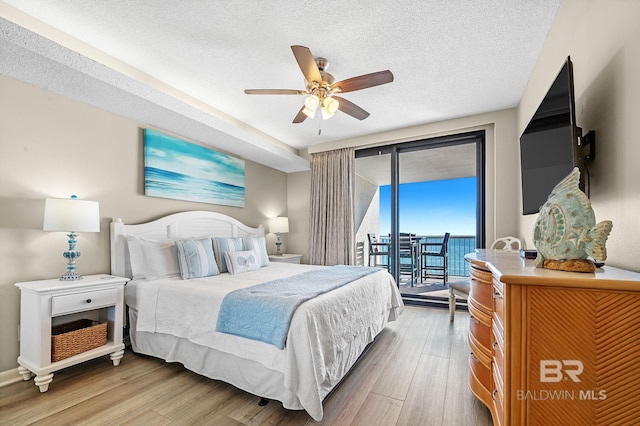 25020 Perdido Beach Blvd Unit 804B, Orange Beach, AL 36561 - bedroom with ceiling fan, hardwood / wood-style flooring, access to outside, and a textured ceiling