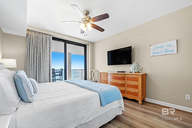25020 Perdido Beach Blvd Unit 804B, Orange Beach, AL 36561 - bedroom with ceiling fan, access to outside, light hardwood / wood-style floors, and a textured ceiling