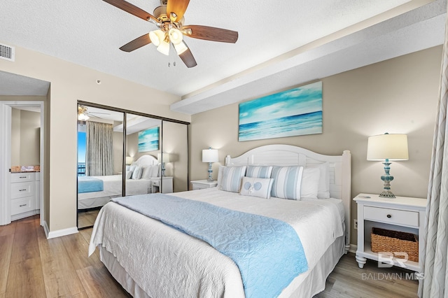 25020 Perdido Beach Blvd Unit 804B, Orange Beach, AL 36561 - bedroom with ceiling fan, a textured ceiling, light hardwood / wood-style floors, and a closet