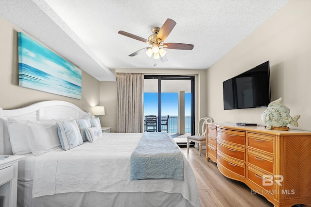 25020 Perdido Beach Blvd Unit 804B, Orange Beach, AL 36561 - bedroom with ceiling fan, access to exterior, a textured ceiling, and light hardwood / wood-style flooring