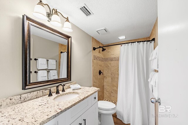 25020 Perdido Beach Blvd Unit 804B, Orange Beach, AL 36561 - bathroom featuring vanity, curtained shower, a textured ceiling, and toilet