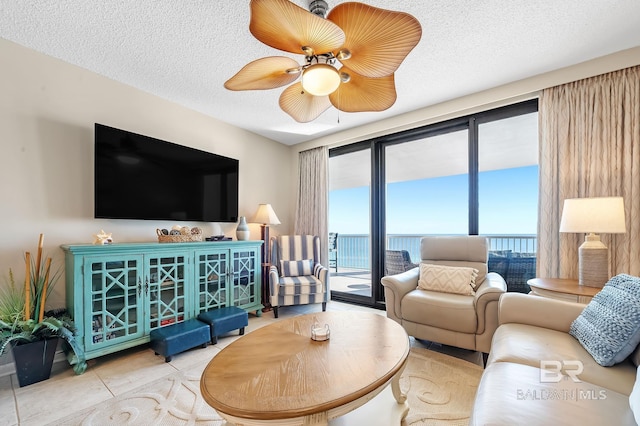 living room featuring tile patterned flooring, ceiling fan, and a textured ceiling