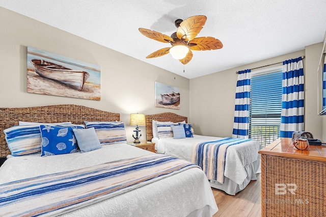 25020 Perdido Beach Blvd Unit 804B, Orange Beach, AL 36561 - bedroom with ceiling fan, light hardwood / wood-style floors, and a textured ceiling