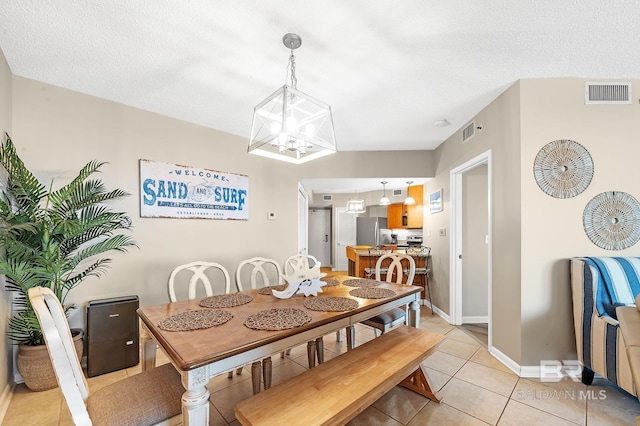 25020 Perdido Beach Blvd Unit 804B, Orange Beach, AL 36561 - dining space with light tile patterned flooring, a textured ceiling, and a notable chandelier