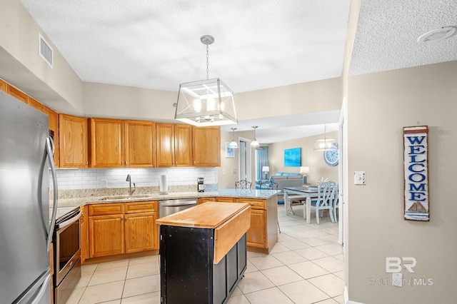 25020 Perdido Beach Blvd Unit 804B, Orange Beach, AL 36561 - kitchen featuring sink, appliances with stainless steel finishes, a kitchen island, decorative light fixtures, and light tile patterned flooring