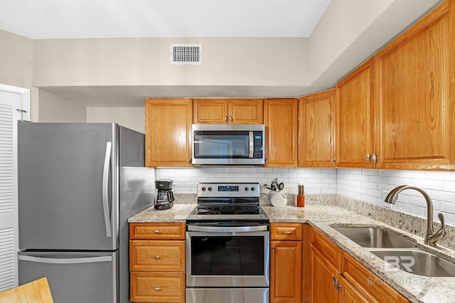 25020 Perdido Beach Blvd Unit 804B, Orange Beach, AL 36561 - kitchen with light stone counters, sink, backsplash, and appliances with stainless steel finishes