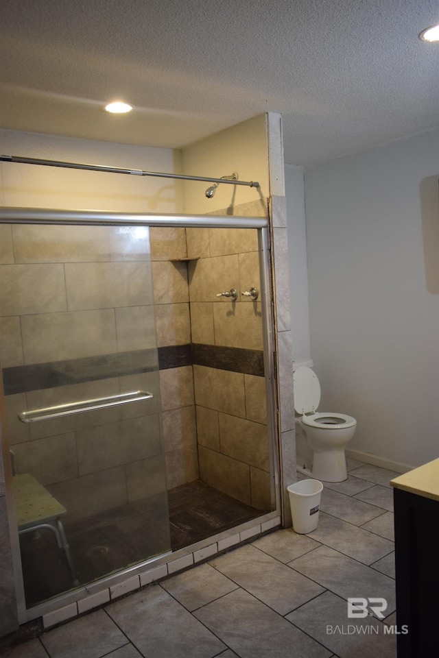 bathroom featuring a textured ceiling, tile floors, a shower with shower door, vanity, and toilet