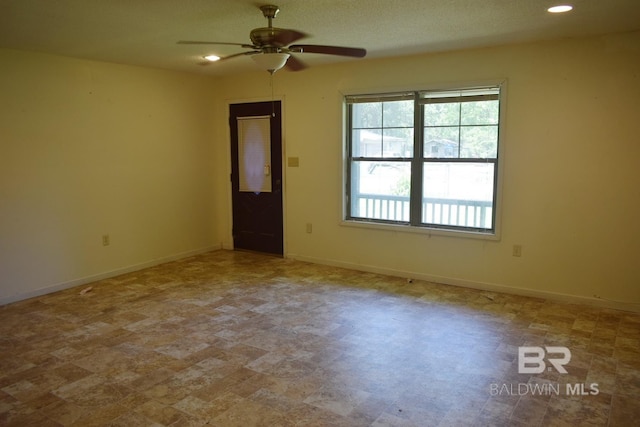 spare room featuring tile flooring and ceiling fan