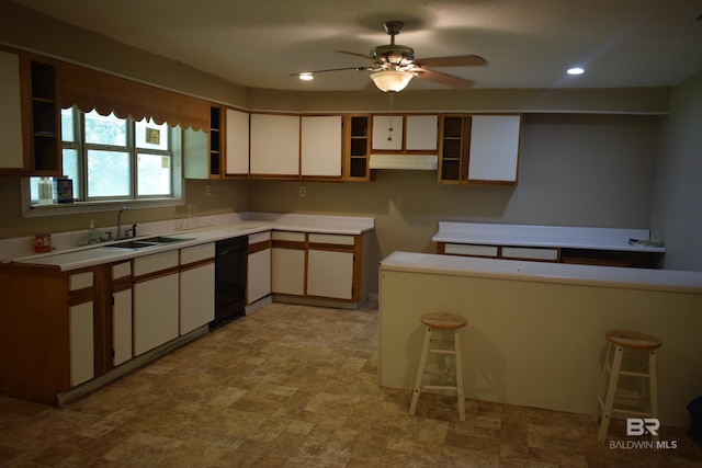 kitchen featuring a breakfast bar area, black dishwasher, sink, ceiling fan, and light tile floors