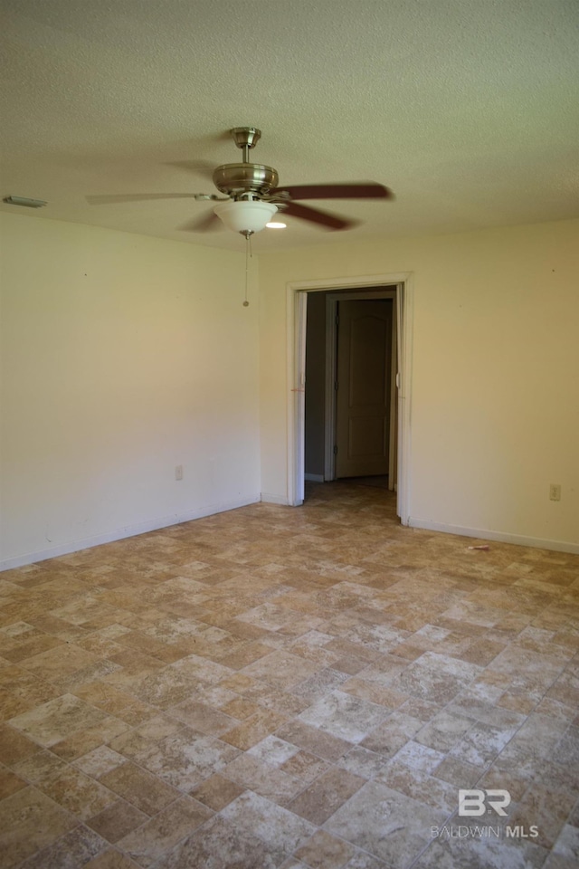 unfurnished room with tile floors, ceiling fan, and a textured ceiling