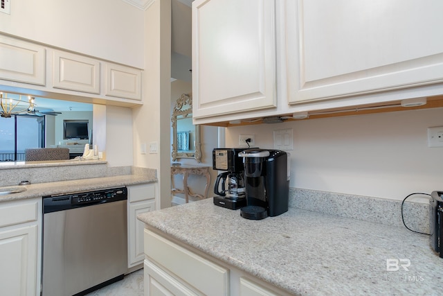 kitchen with white cabinets, stainless steel dishwasher, a notable chandelier, and light stone counters