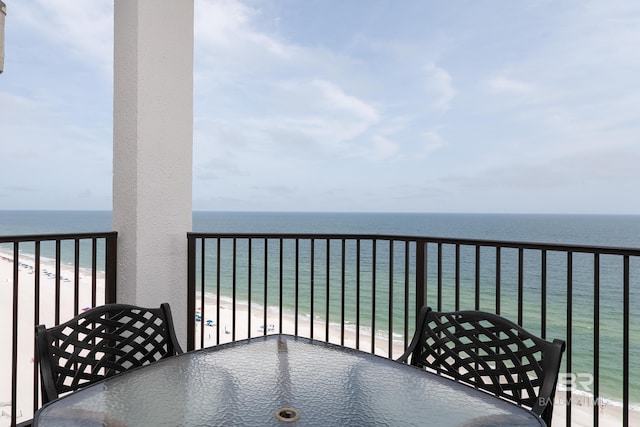 balcony with a water view and a view of the beach