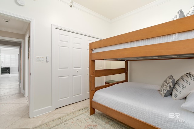 bedroom featuring crown molding, a closet, and light tile patterned floors