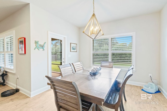 dining area with light hardwood / wood-style floors and a notable chandelier