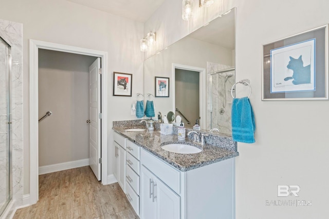 bathroom featuring a shower with shower door, vanity, and wood-type flooring