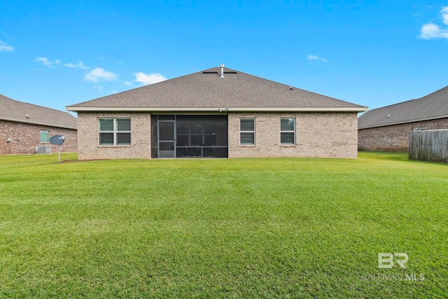 back of property with a sunroom and a yard