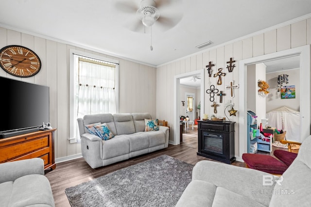 living room featuring crown molding, dark wood-type flooring, and ceiling fan