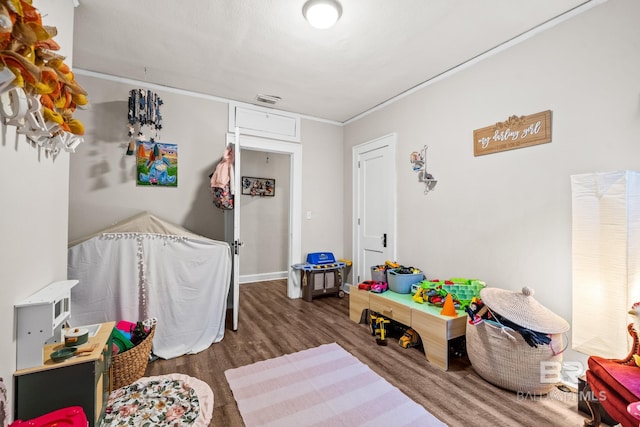 game room with crown molding and dark hardwood / wood-style flooring