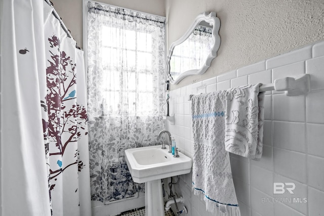 bathroom with sink and tile walls