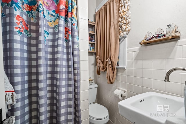 bathroom featuring tile walls, sink, toilet, and walk in shower