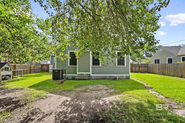 back of house with a yard and central AC