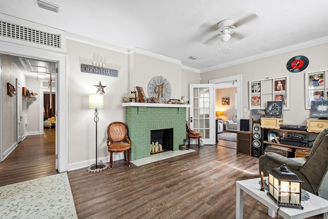 living room featuring ornamental molding, dark wood-type flooring, ceiling fan, and a fireplace