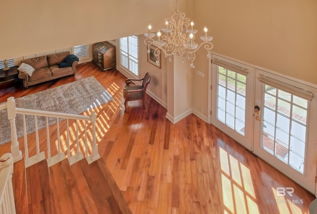 unfurnished living room with hardwood / wood-style flooring and an inviting chandelier