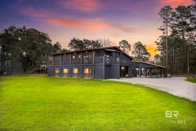 rear view of property featuring driveway, stairway, and a yard