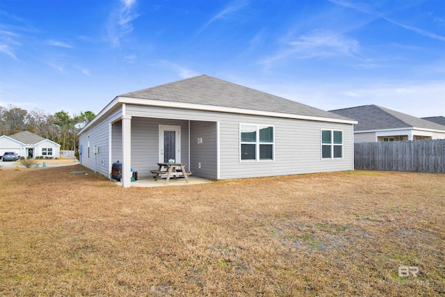 rear view of house featuring a yard and a patio area